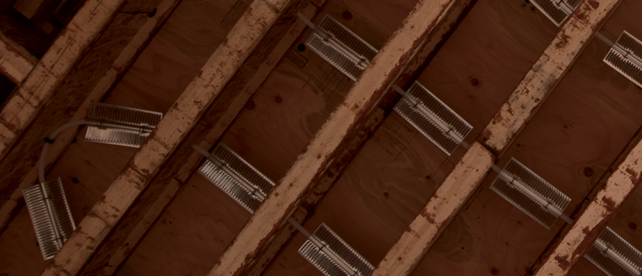 Fin assembly installed between joists — dramatic side view